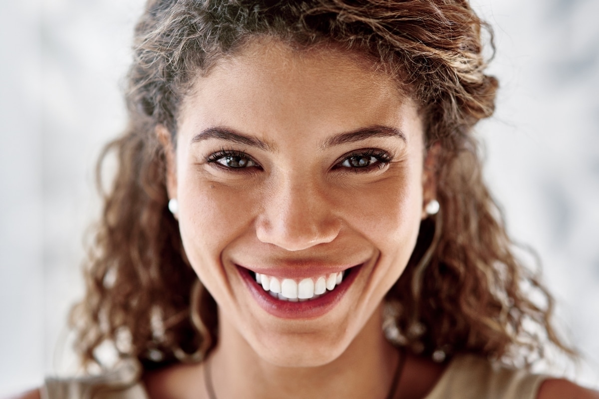 Woman showing a bright, stain-free smile after professional teeth whitening