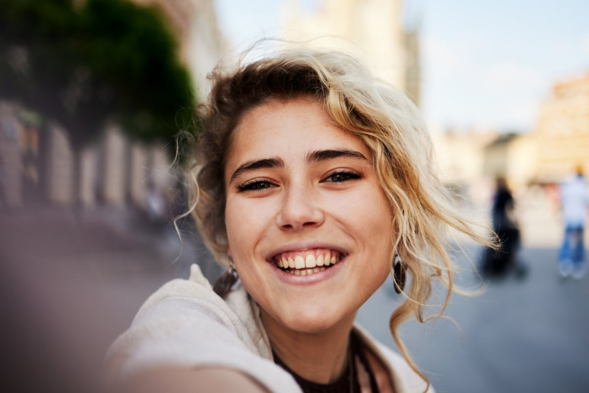 Woman smiling while receiving care for dental bonding
